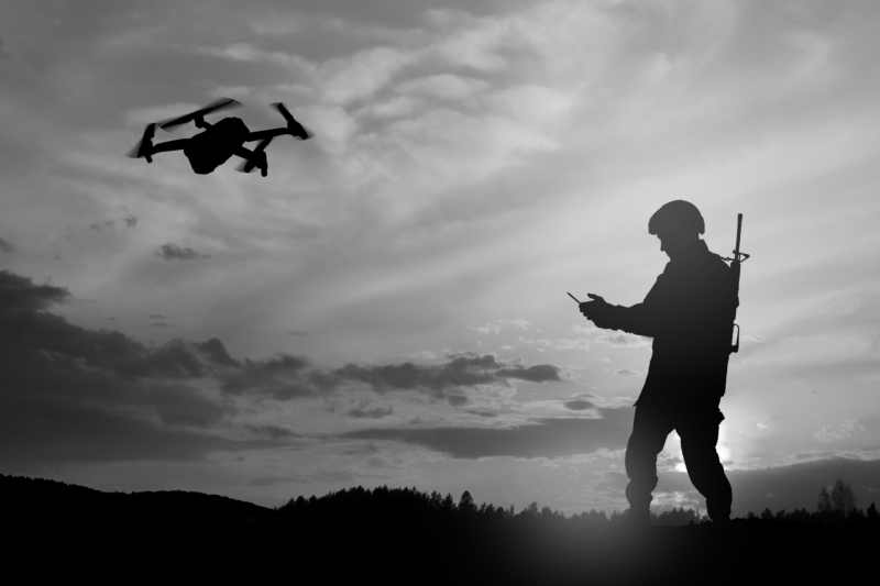 Silhouette of soldier are using drone and laptop computer for scouting during military operation.
